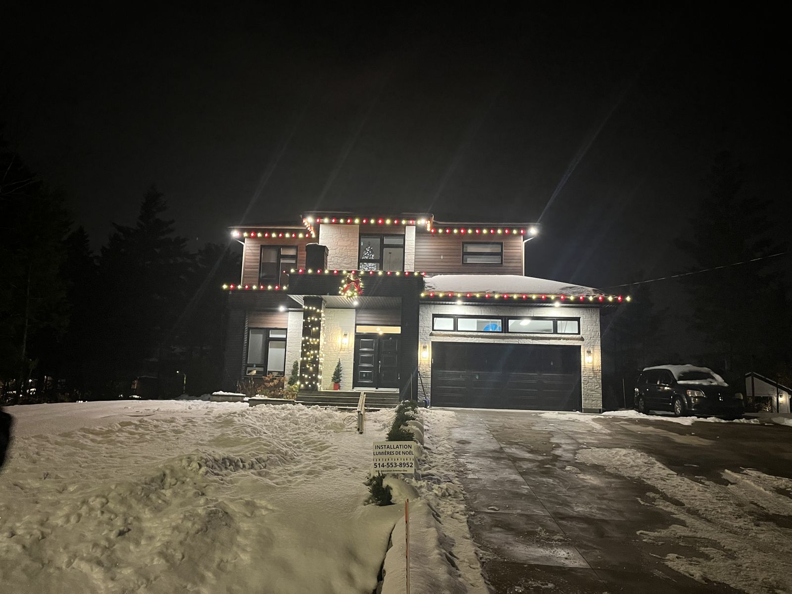Installation de lumières de Noël sur une grande maison moderne